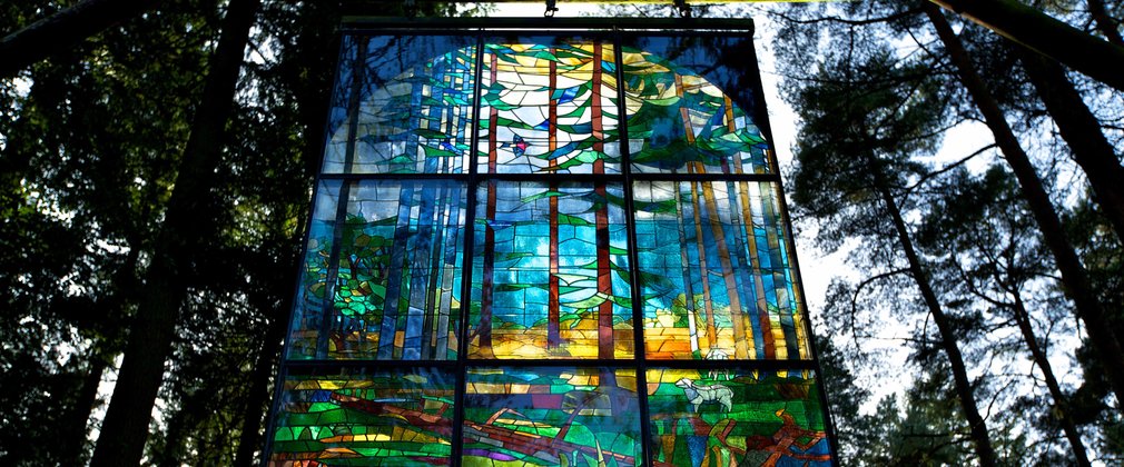 Stained glass pannel hanging in the canopy at beechenhurst sculpture trail