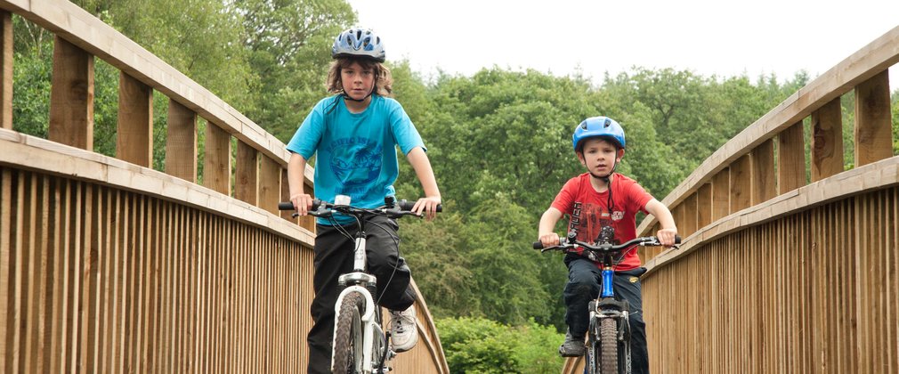 two boys cycling in the forest on a cycle route 