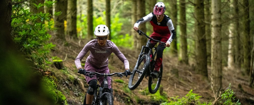 Two mountain bike riders on a forest cycle trail