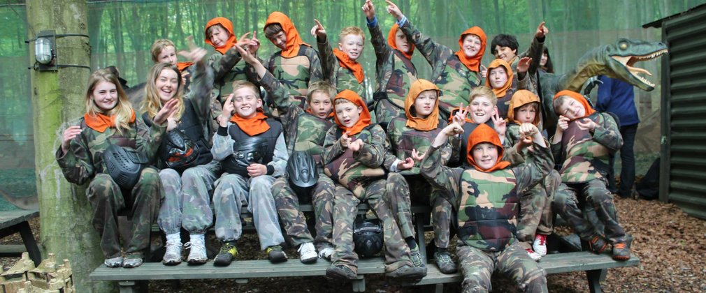 Group of children smiling at a paintballing centre