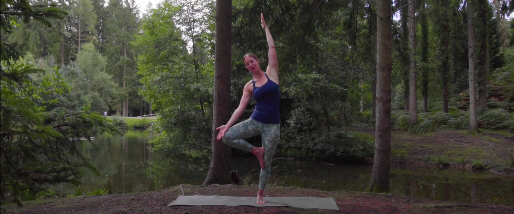 Woman teaching yoga in the forest