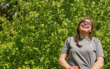 Female forestry volunteer laughing at work 