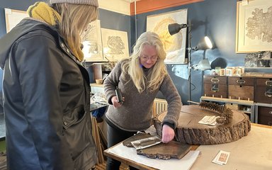 Two women in an artists studio looking at nature inspired work