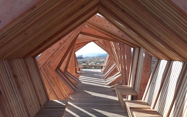 View through a striking timber shelter structure with view in the distance