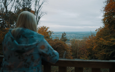 Vanessa Feltz looking out over the woodland from a viewpoint.