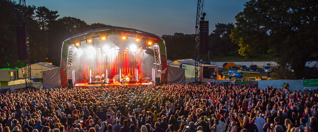Crowds of people in front of the illuminated stage at Delamere.
