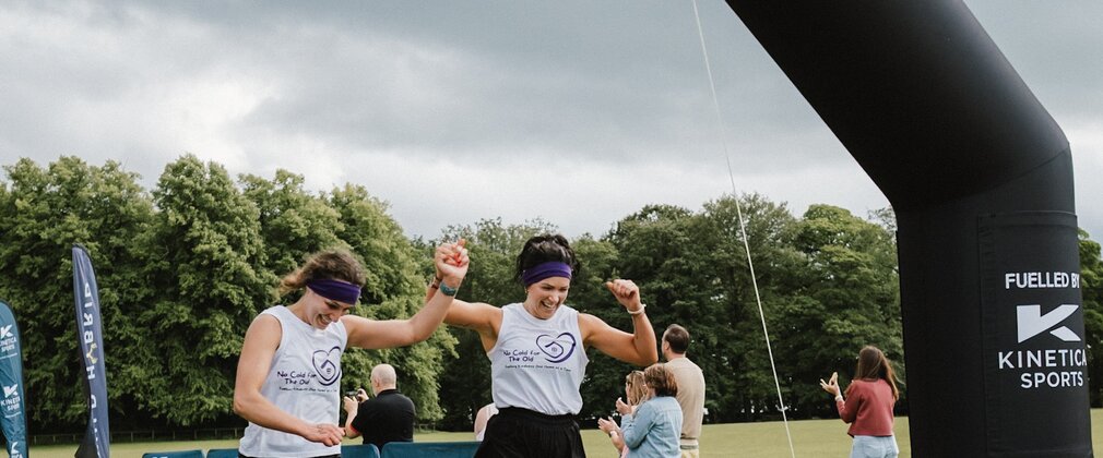 women cross the finish line in pairs event