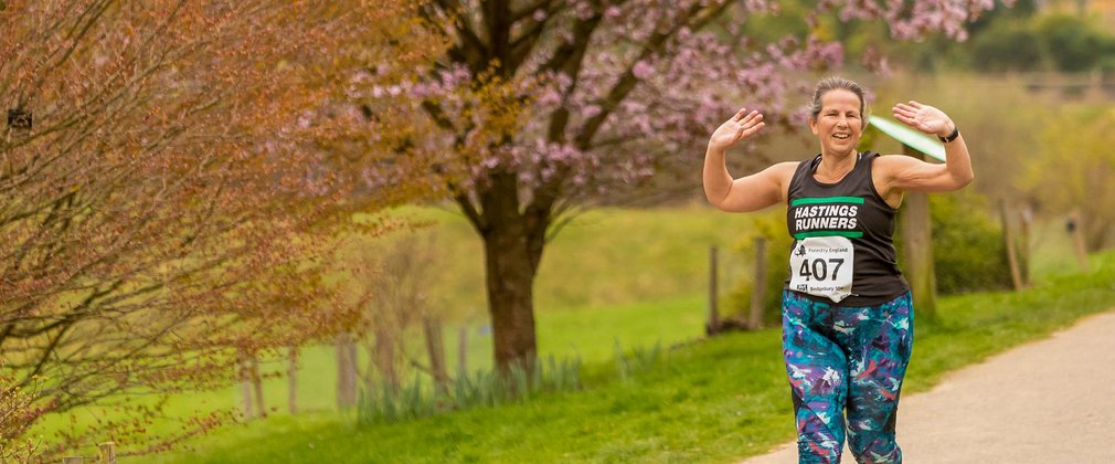 Forestry 100 Running Series, woman finishing race at Bedgebury