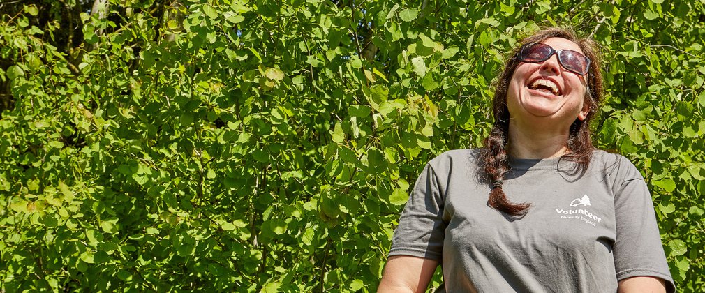 Female forestry volunteer laughing at work 