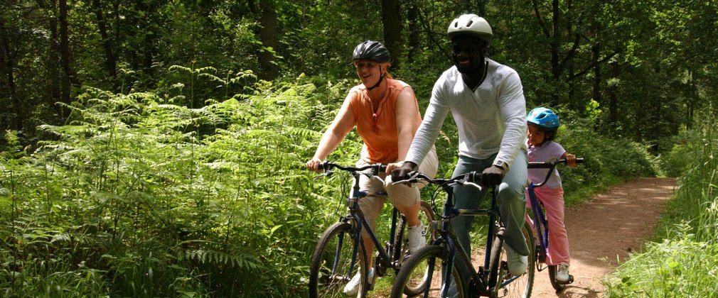 Family cycling through Hamsterley forest, blue mountain bike trail