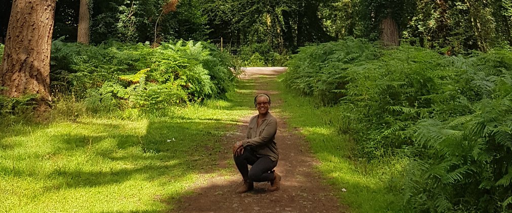 Zakiya Mckenzie crouched on forest floor