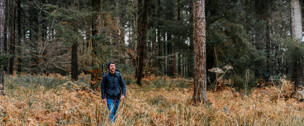 A man walking through a forest clearing