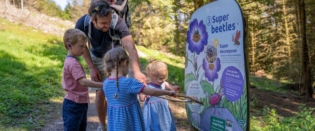 Family looking at Superworm trail in a forest