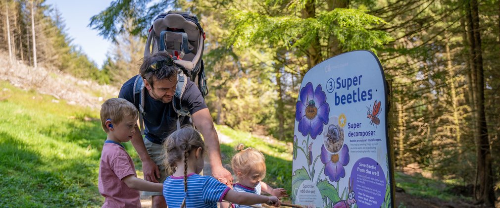 A family interacting with a Superworm interpretation board