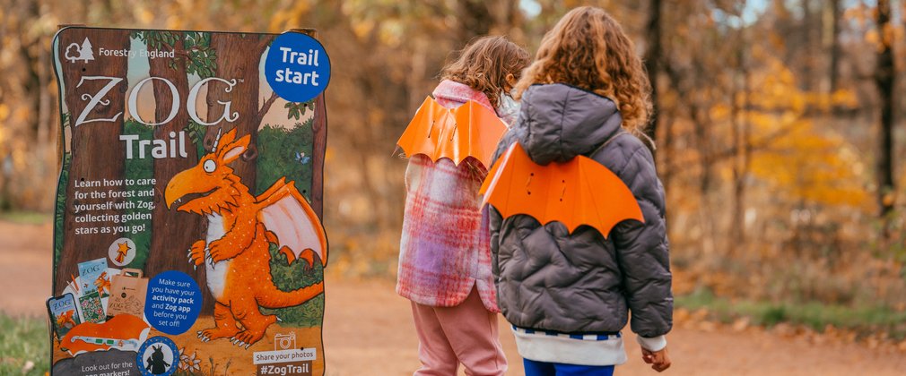 Two children next to Zog trail in a forest