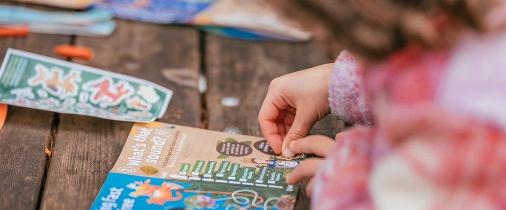 Child adding stickers to a Zog pack