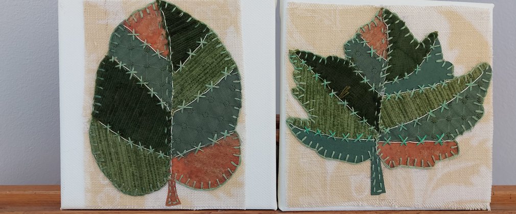 A patch work piece of art in the shape of leaves. 