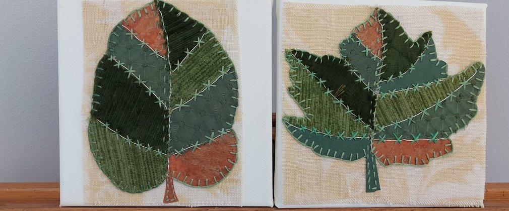 A patch work piece of art in the shape of leaves.