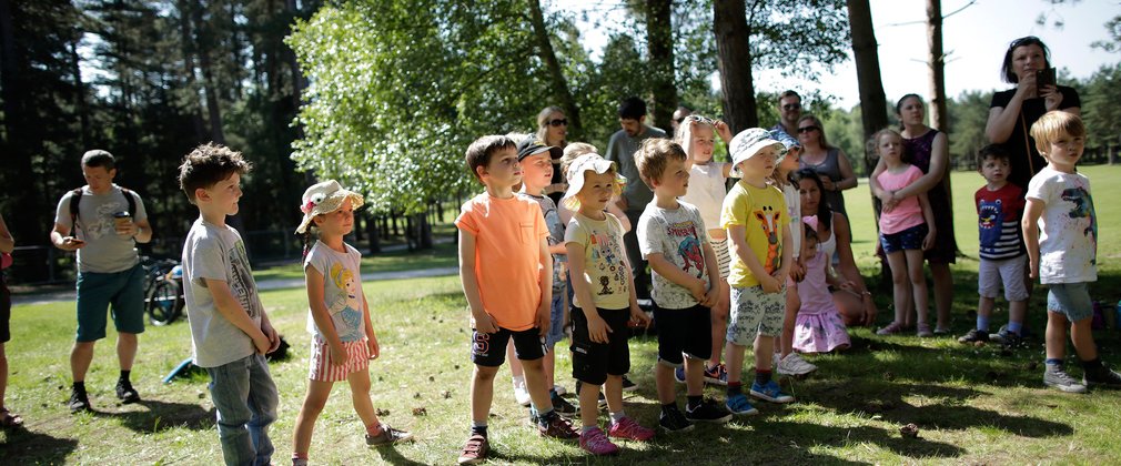A group of young children in summer clothing are standing together 