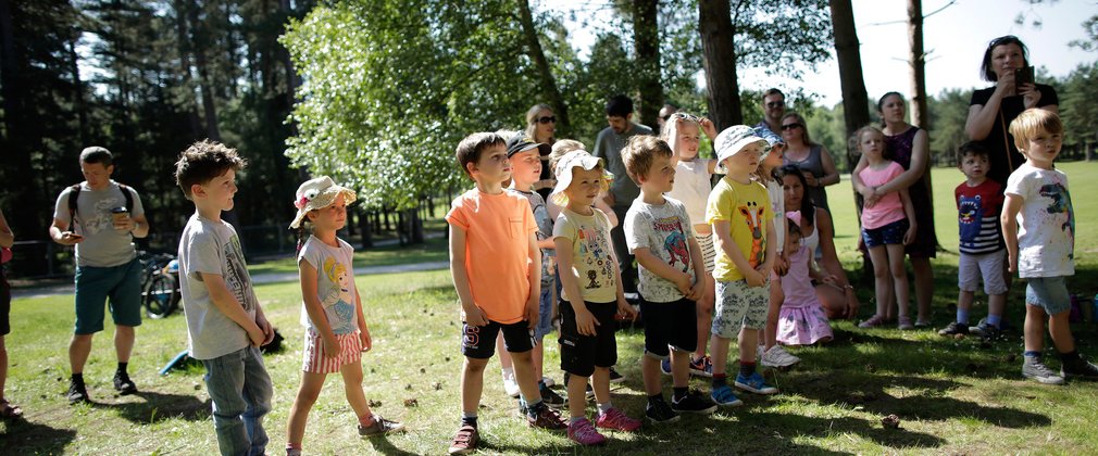 A group of young children in summer clothing are standing together