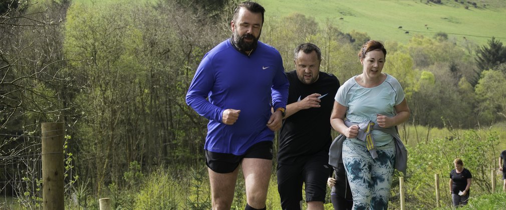 Runners going uphill in the forest 