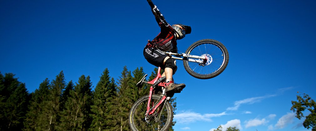 Mountain Biker doing jump and stunts in the forest 