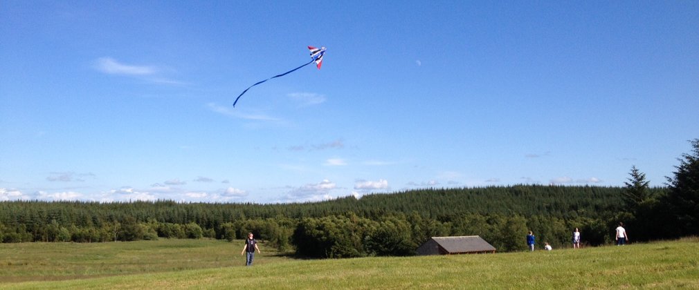 Someone flying a kite in a open field at Gisburn 