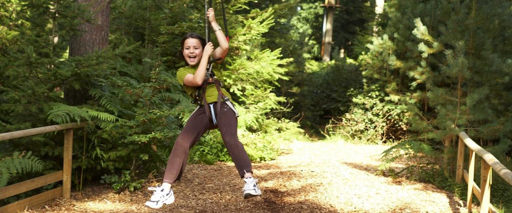 Child flying through the woods on a zip wire 