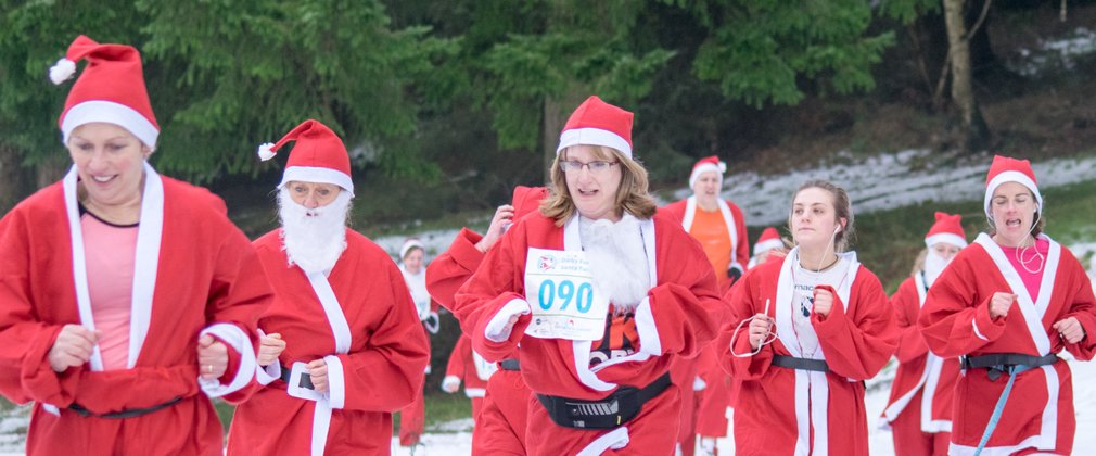 Runners dressed as Santa during a snowy fun run
