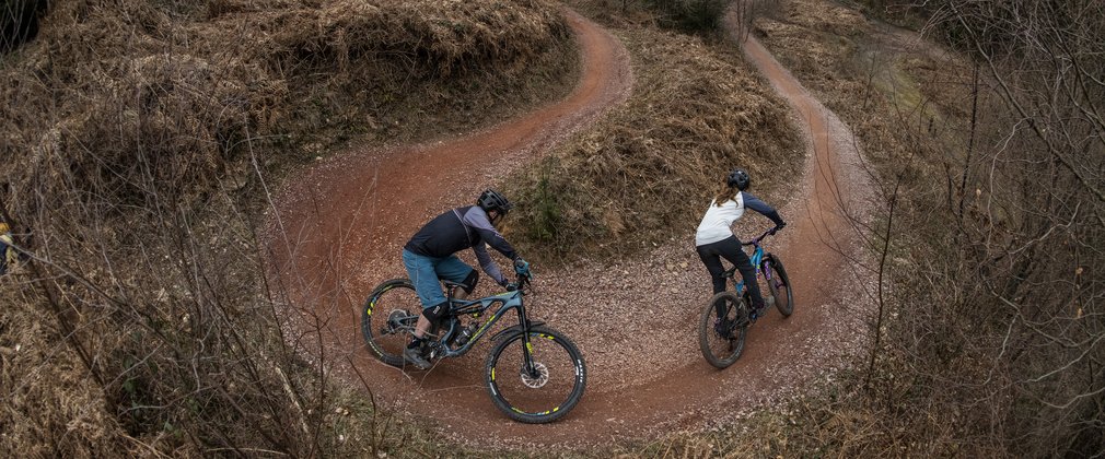 Two riders cycling around a bend in the Forest of Dean