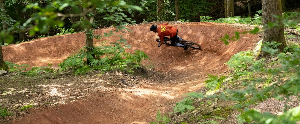 Mountain bike rider on a berm in a forest