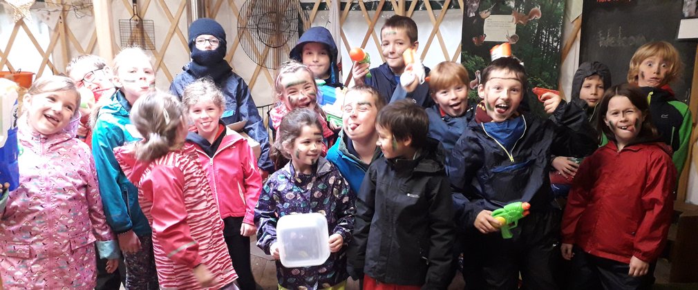 Group of children in yurt posing with silly faces 