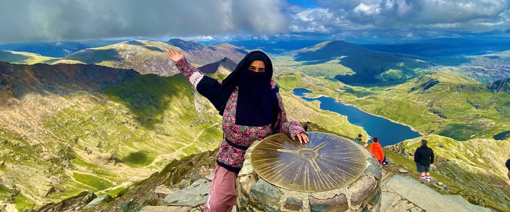 Amira poses at the top of a mountain