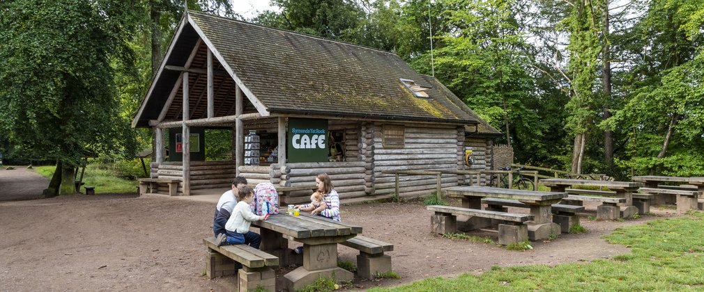 Family enjoying lunch outside a woodland cafe