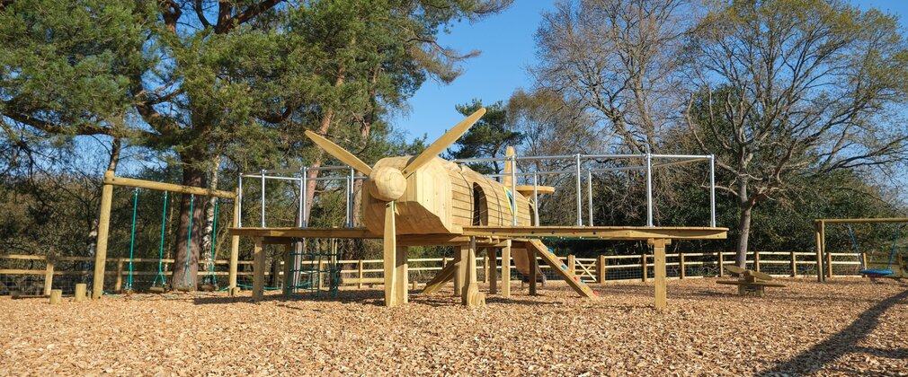 Wooden play area in the shape of a Spitfire plane at New Forest campsite