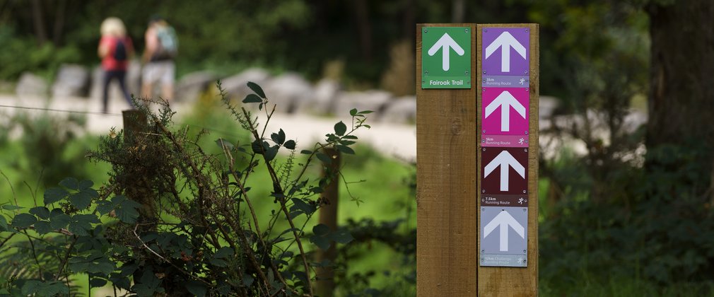 Way markers for walking routes in the foreground and two walkers in the background