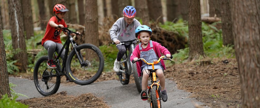 three children riding mountain bikes