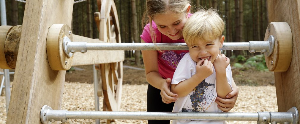 Boy and girl playing in a purpose built play area