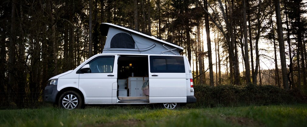 Campervan in the woods with side door open