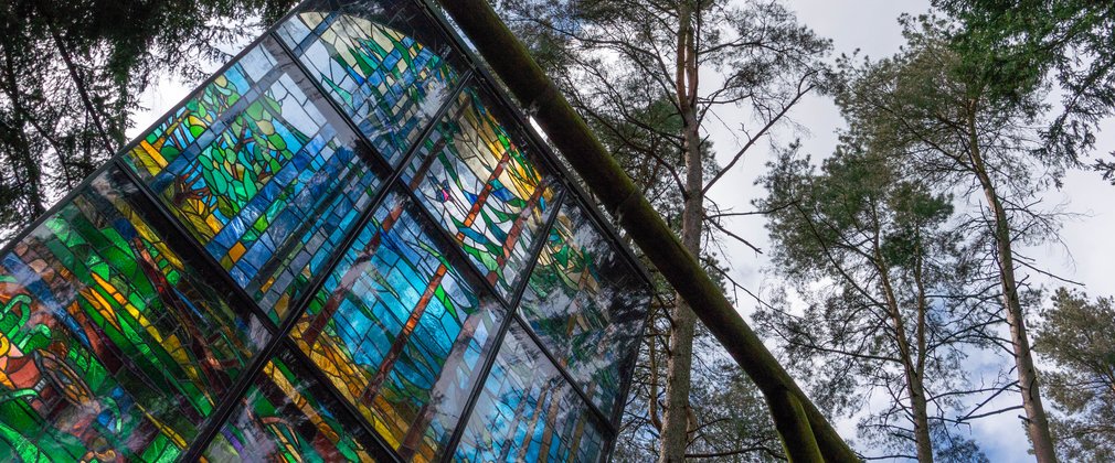 Large stained glass window hanging from the trees