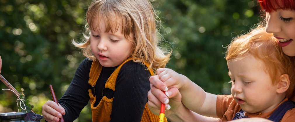 Girl and boy painting in the forest