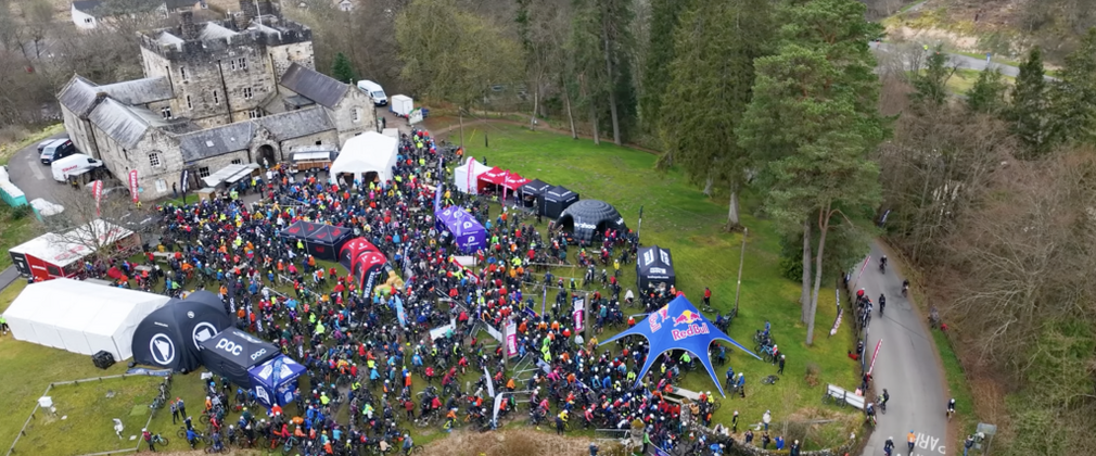 A drone shot of a a bike event outside a historic building