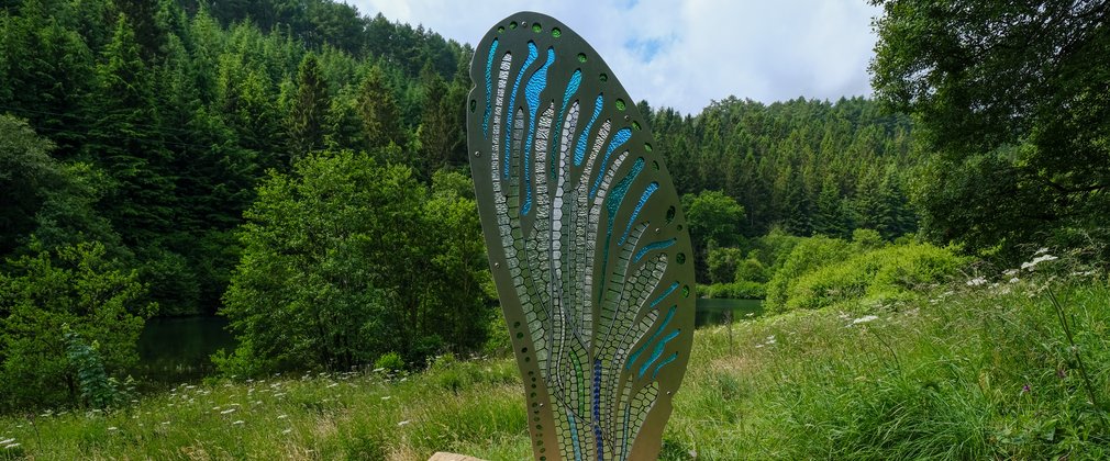A mental and glass sculpture of a dragonfly wing