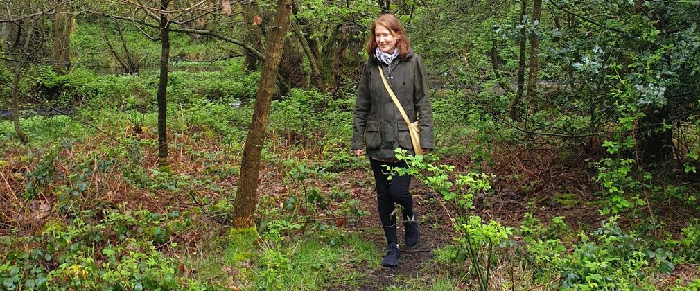 Woman walking in woods footpath