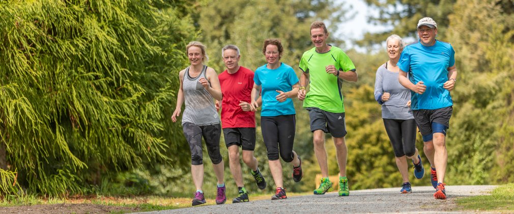 A group of men and women running along a path