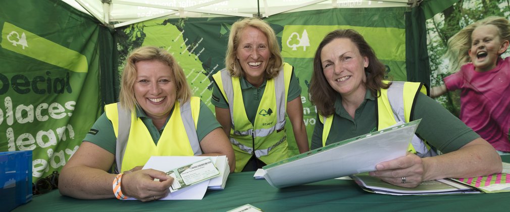 Three women sat behind ticket bench at Forest Live concert