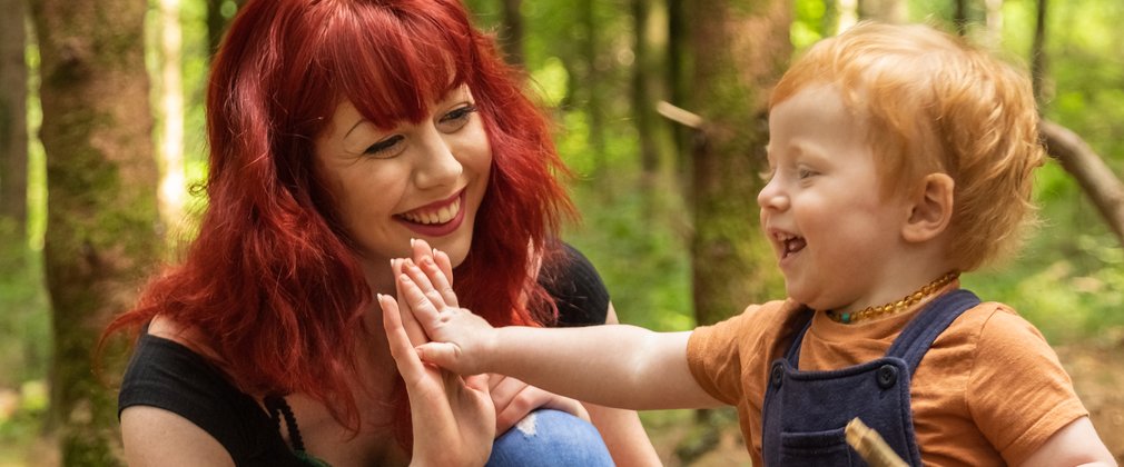 woman and child playing in forest