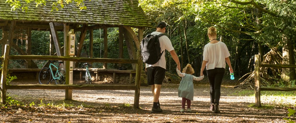 Family walking past a wooden structure