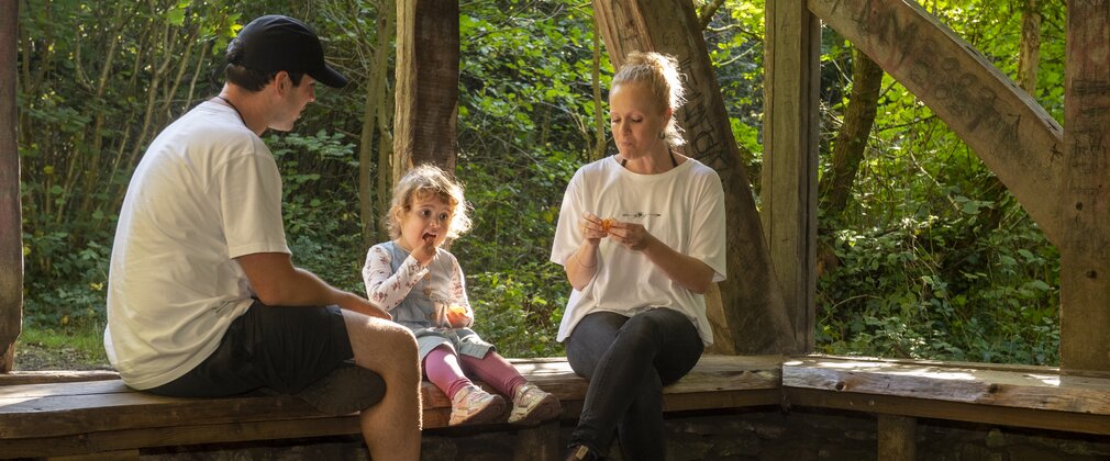 A family enjoying a snack break in a wooden shelter