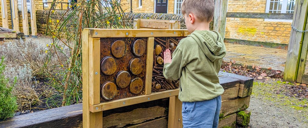 Young boy using the touch boards in the Fineshade Wood sensory garden